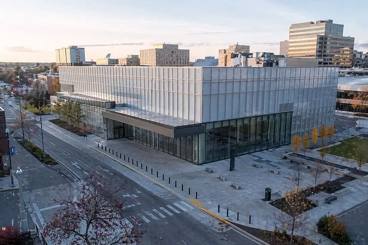 A modern glass building situated on a city street corner